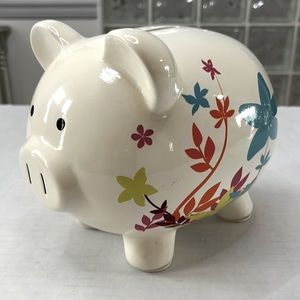 Piggybank with modern floral design. Ceramic. Cream background.